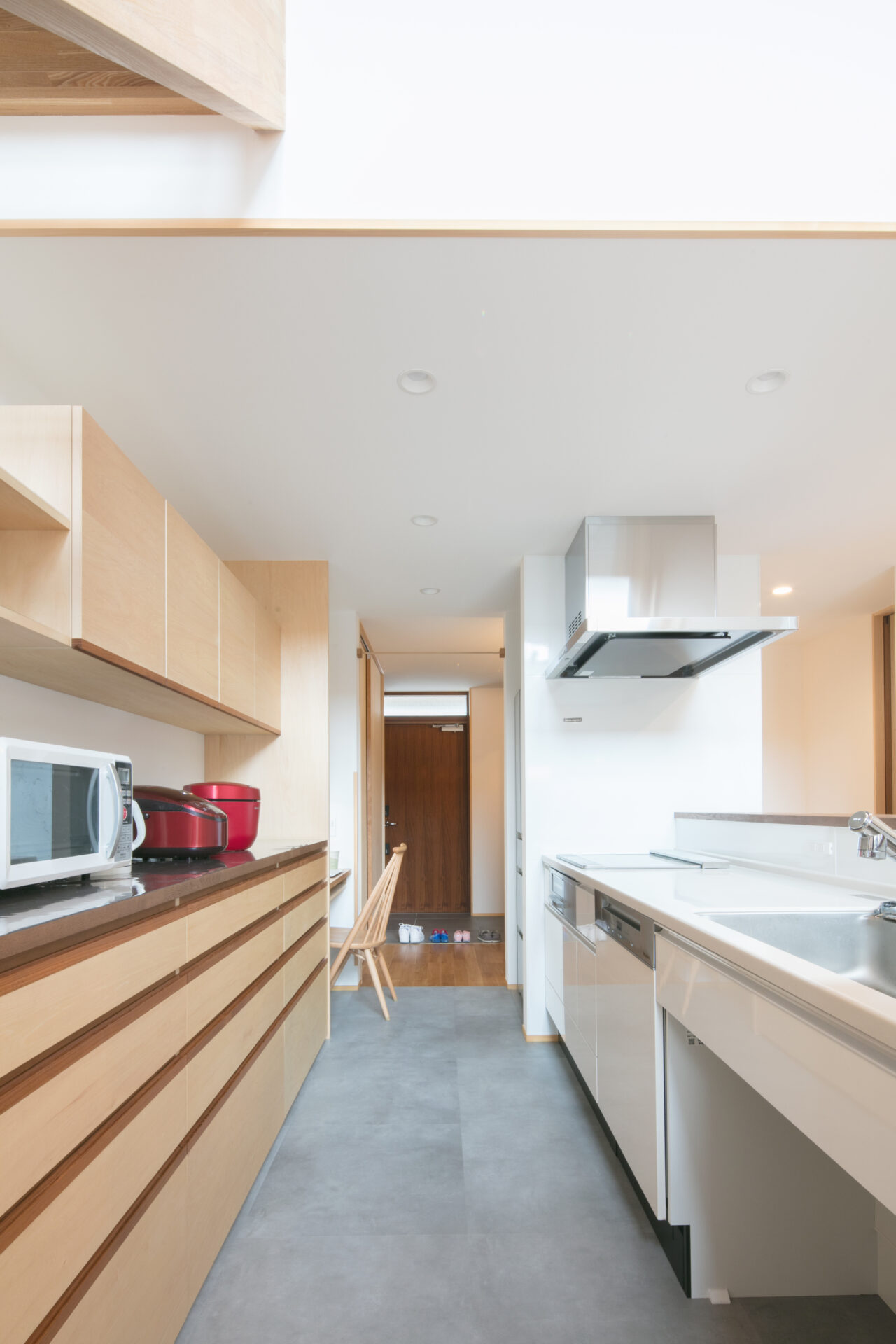 大工の手仕事による造作カップボード（食器棚）。既製品にはない木の温かみと、天井まで無駄なく使える収納力が魅力。ゴミ箱スペースも計画的に配置しました。