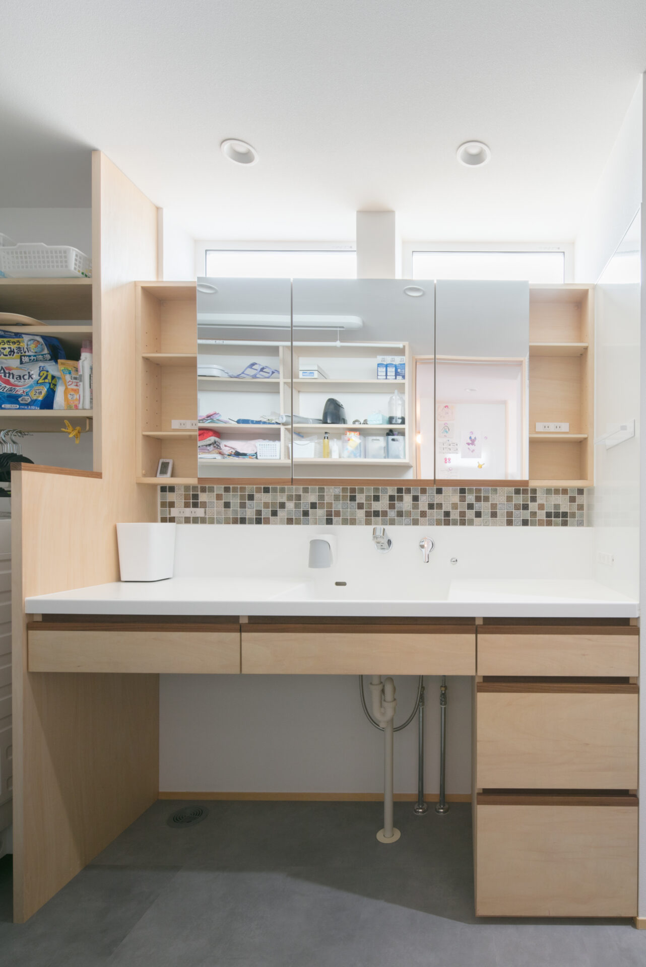 モザイクタイルが可愛らしい、世界に一つの造作洗面台。幅広のカウンターは忙しい朝の身支度もスムーズに。足元には収納たっぷりの引き出しを備えました。